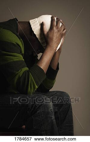 Stock Photo - A young adult deep in thought, possibly frustrated.. Fotosearch