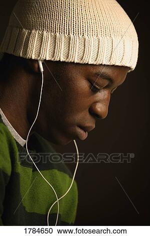 Stock Image - A young adult listening to music.. Fotosearch