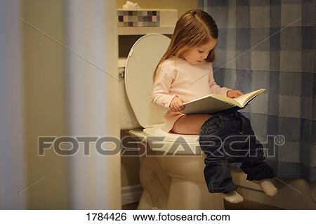 Stock Photograph - Child reads a book on the potty. Fotosearch
