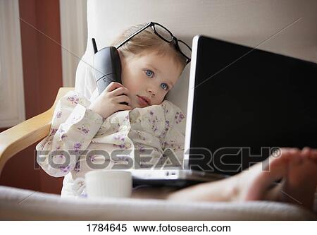 Stock Photography - Child working on phone and computer. Fotosearch