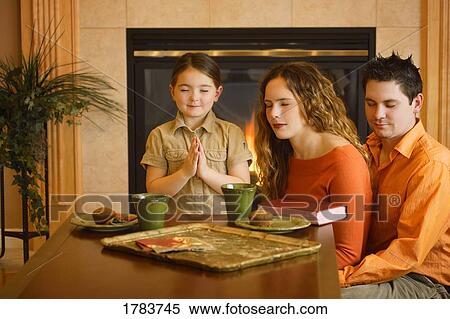 Family of three praying before a meal View Large Photo Image Stock Photography - Family of three praying before a meal. Fotosearch