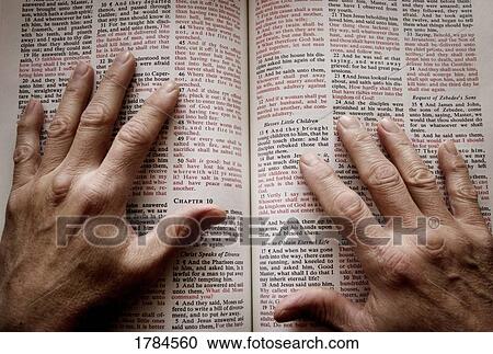 Stock Image - Hands on open Bible. Fotosearch