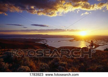 Stock Image - Mountain biker, Warner Potholes, Hart Mountain Wildlife Reguge, sunset.. Fotosearch