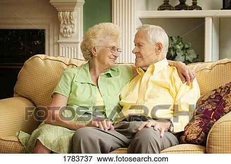 Stock Photo - Senior couple sitting on the sofa together. Fotosearch