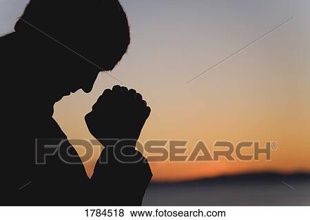 Stock Photo - Silhouette of a man praying. Fotosearch