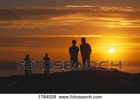 Silhouetted figures in sunset View Large Photo Image Stock Photo - Silhouetted figures in sunset. Fotosearch