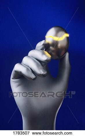 Stock Photo - Silver hand holding cracked silver egg. Fotosearch