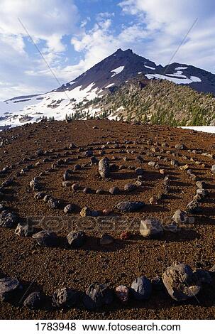Stock Photo - Spiral rock art, view of Three Sisters mountain peaks, Deschutes National Forest. Fotosearch