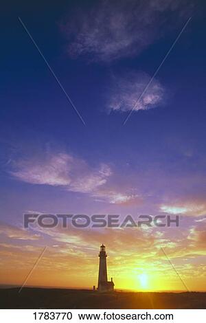 Stock Image - Sunset behind Yaquina Head Lighthouse, Yaquina Bay. Fotosearch