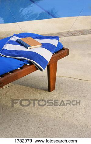 Towel, chair and book by pool View Large Photo Image Stock Photo - Towel, chair and book by pool. Fotosearch