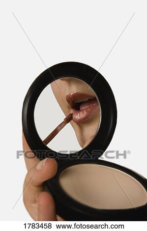 Stock Photo - Woman applying lipstick. Fotosearch