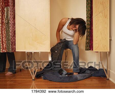 Stock Image - Woman trying on jeans. Fotosearch