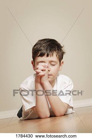 Stock Image - Young boy praying. Fotosearch