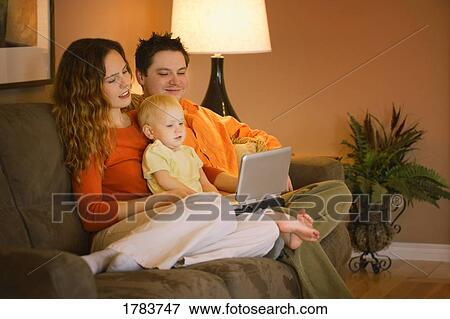 Stock Photo - young family watching movie on portable DVD player. Fotosearch