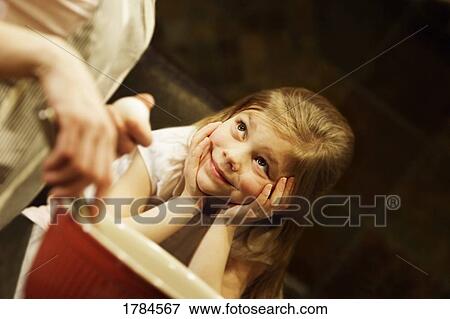 Young girl watching mother bake View Large Photo Image Stock Photo - Young girl watching mother bake. Fotosearch