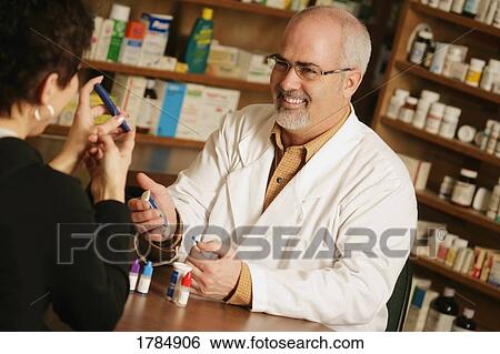 Stock Photograph - A customer seeks advise from a pharmacist.. Fotosearch