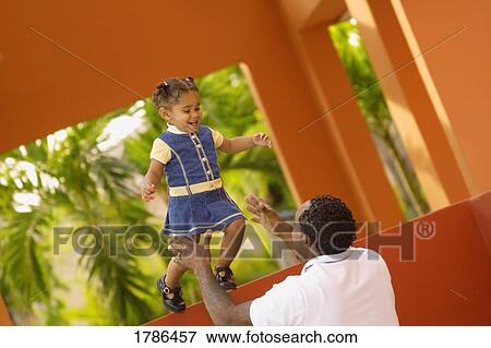 Stock Photo - A father and baby daughter bonding. Fotosearch
