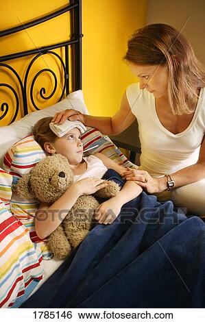 A mother attending her sick daughter View Large Photo Image Stock Photograph - A mother attending her sick daughter. Fotosearch