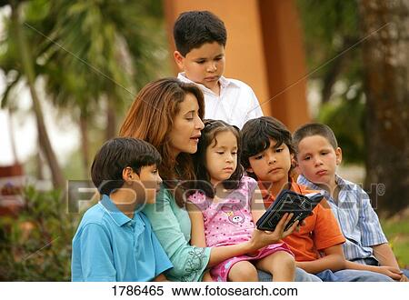 A woman reading to a group of children View Large Photo Image Stock Photography - A woman reading to a group of children. Fotosearch