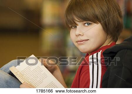 A young boy with a book View Large Photo Image Stock Photograph - A young boy with a book. Fotosearch