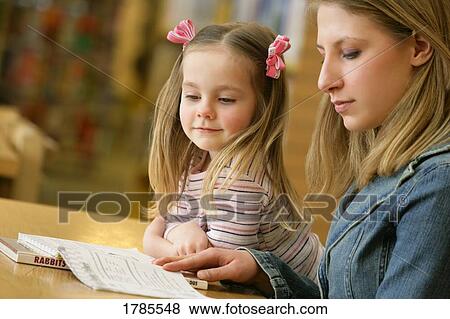 Stock Photo - Adult and young girl reading. Fotosearch