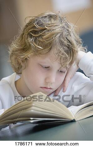 Stock Image - Boy reading book. Fotosearch