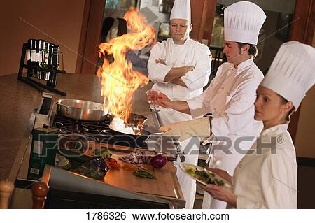 Chefs preparing food in kitchen View Large Photo Image Stock Photograph - Chefs preparing food in kitchen. Fotosearch