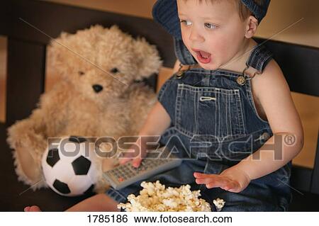 Stock Photograph - Child watching sports game on television. Fotosearch