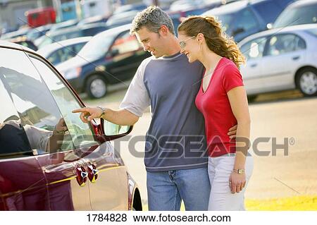 Stock Photo - Couple interested in a car. Fotosearch
