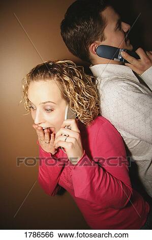 Couple talking on cell phones View Large Photo Image Stock Photograph - Couple talking on cell phones. Fotosearch