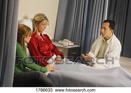 Stock Image - Doctor telling patient her diagnosis. Fotosearch