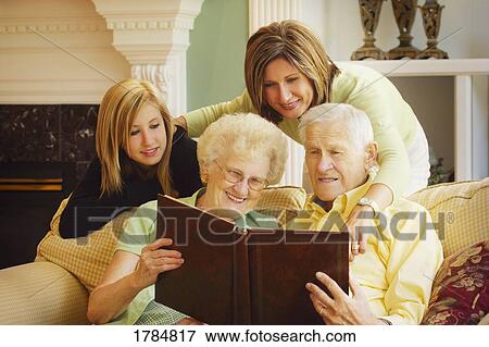 Family looking at photo album View Large Photo Image Stock Photo - Family looking at photo album. Fotosearch