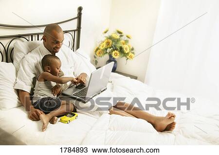 Father and son playing on laptop View Large Photo Image Stock Image - Father and son playing on laptop. Fotosearch