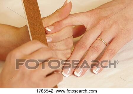 Stock Image - Fingernail being filed. Fotosearch