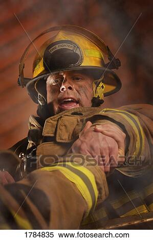 Stock Photography - Firefighter helping another. Fotosearch