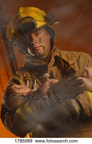 Fireman rescuing a baby View Large Photo Image Stock Photo - Fireman rescuing a baby. Fotosearch