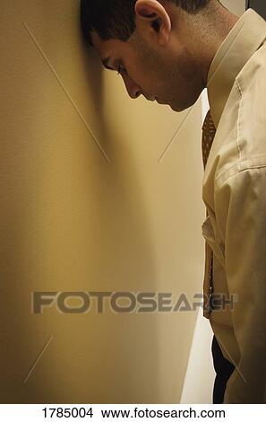 Frustrated man leaning head against wall View Large Photo Image Picture - Frustrated man leaning head against wall. Fotosearch