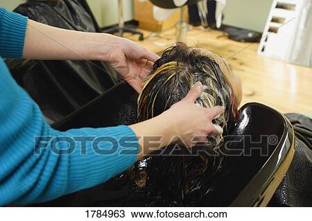Stock Image - Geting hair washed at a hair salon. Fotosearch