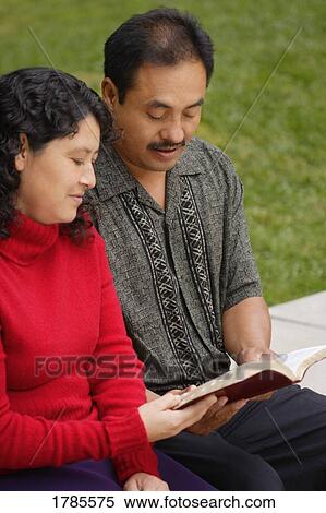 Stock Photography - Latino couple reading the Bible. Fotosearch