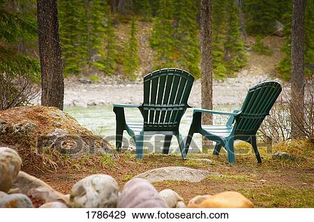 Stock Photo - Lawn chairs situated by the lake. Fotosearch