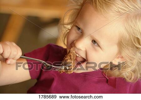 Little girl eating cake View Large Photo Image Stock Photo - Little girl eating cake. Fotosearch