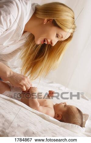 Stock Photo - Mother plays with baby. Fotosearch