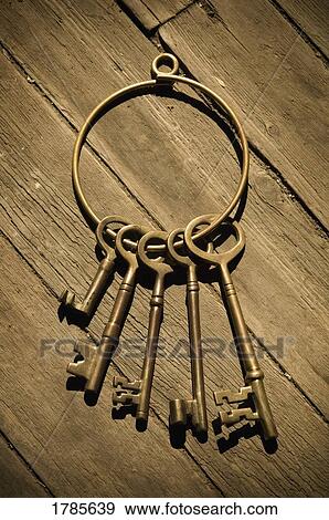Stock Photo - Old-fashioned skeleton keys laying on distressed wood floor. Fotosearch