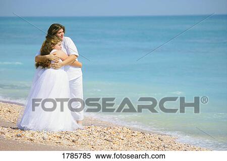 Stock Photography - Parent embracing child on the beach. Fotosearch