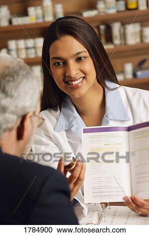 Pharmacist explains instructions on medication View Large Photo Image Stock Image - Pharmacist explains instructions on medication. Fotosearch