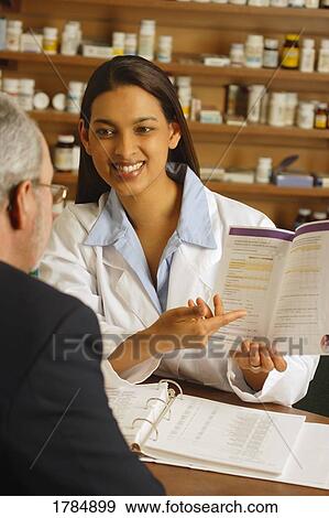 Pharmacist giving patient medical advice View Large Photo Image Stock Photo - Pharmacist giving patient medical advice. Fotosearch