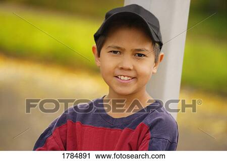 Stock Image - Portrait of a boy leaning against a post. Fotosearch