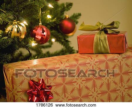 Stock Photograph - Presents under a Christmas tree. Fotosearch