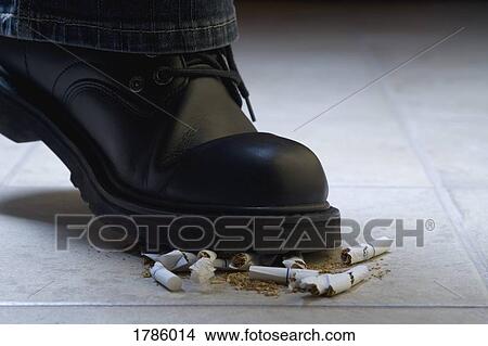 Picture - Shoe squishing cigarettes. Fotosearch