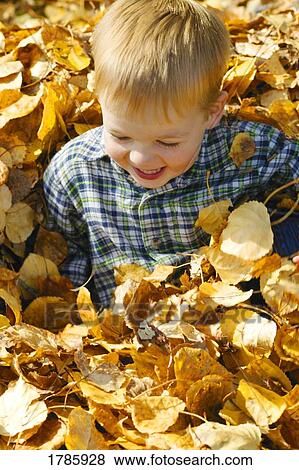 Stock Photo - Toddler playing in autumn leaves. Fotosearch